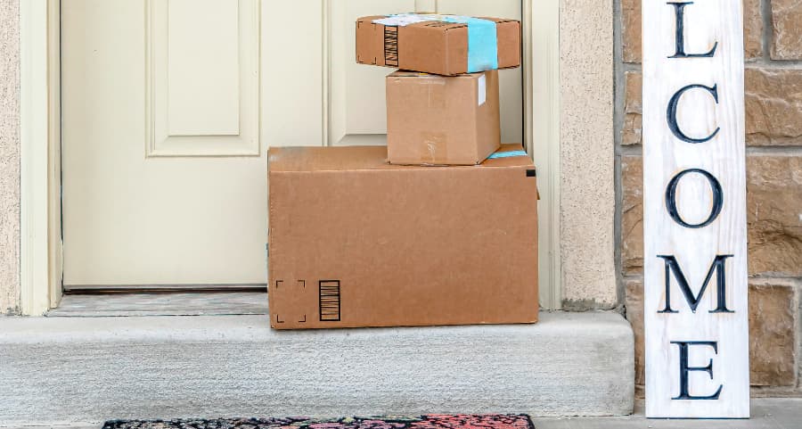 Boxes by the door of a residence with a welcome sign in Boston